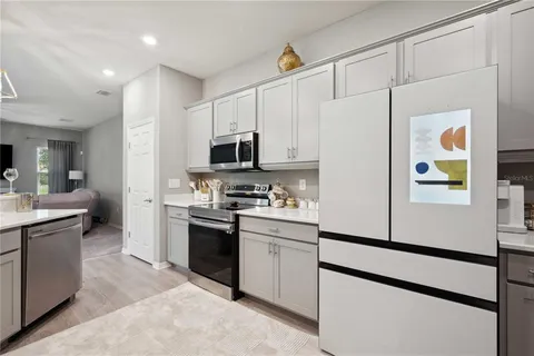 a kitchen with stainless steel appliances a refrigerator sink and microwave