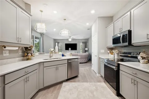a kitchen with stainless steel appliances granite countertop a sink and dishwasher a stove top oven with white countertops