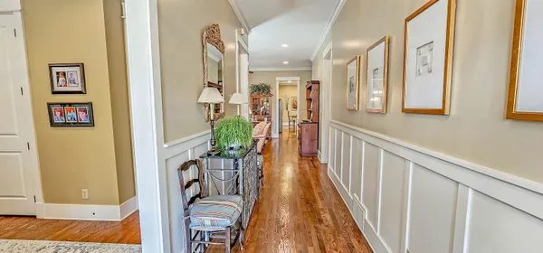 a view of a hallway with wooden floor and windows