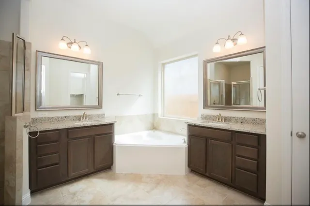 a bathroom with a tub sink and mirror