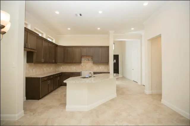 a large white kitchen with a sink and dishwasher a stove top oven with wooden floor