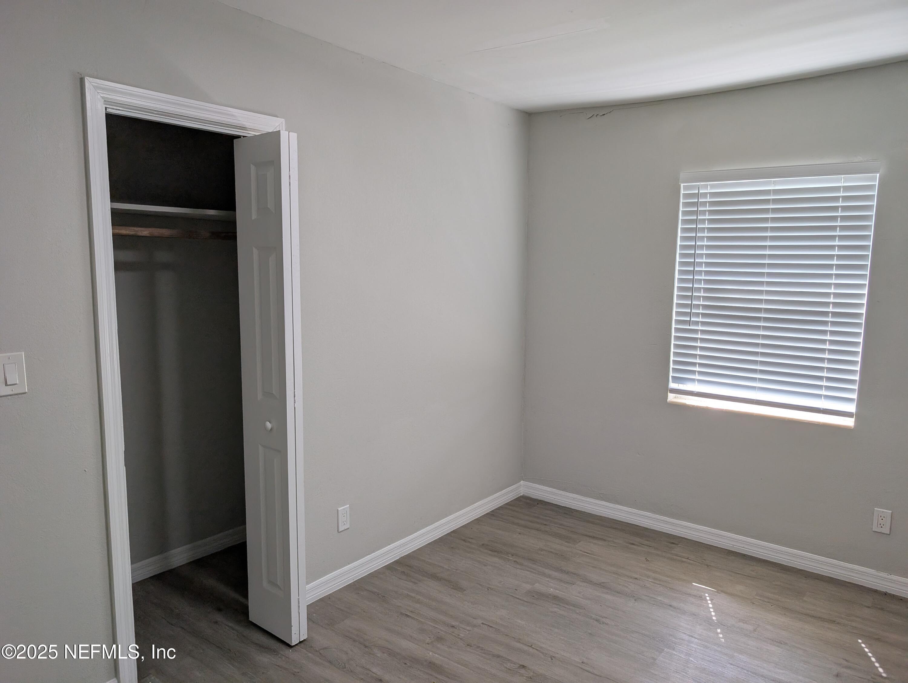 1339 Ellis Road South Jacksonville, FL 32205 - Photo 14 of 26 a view of an empty room with wooden floor and a window