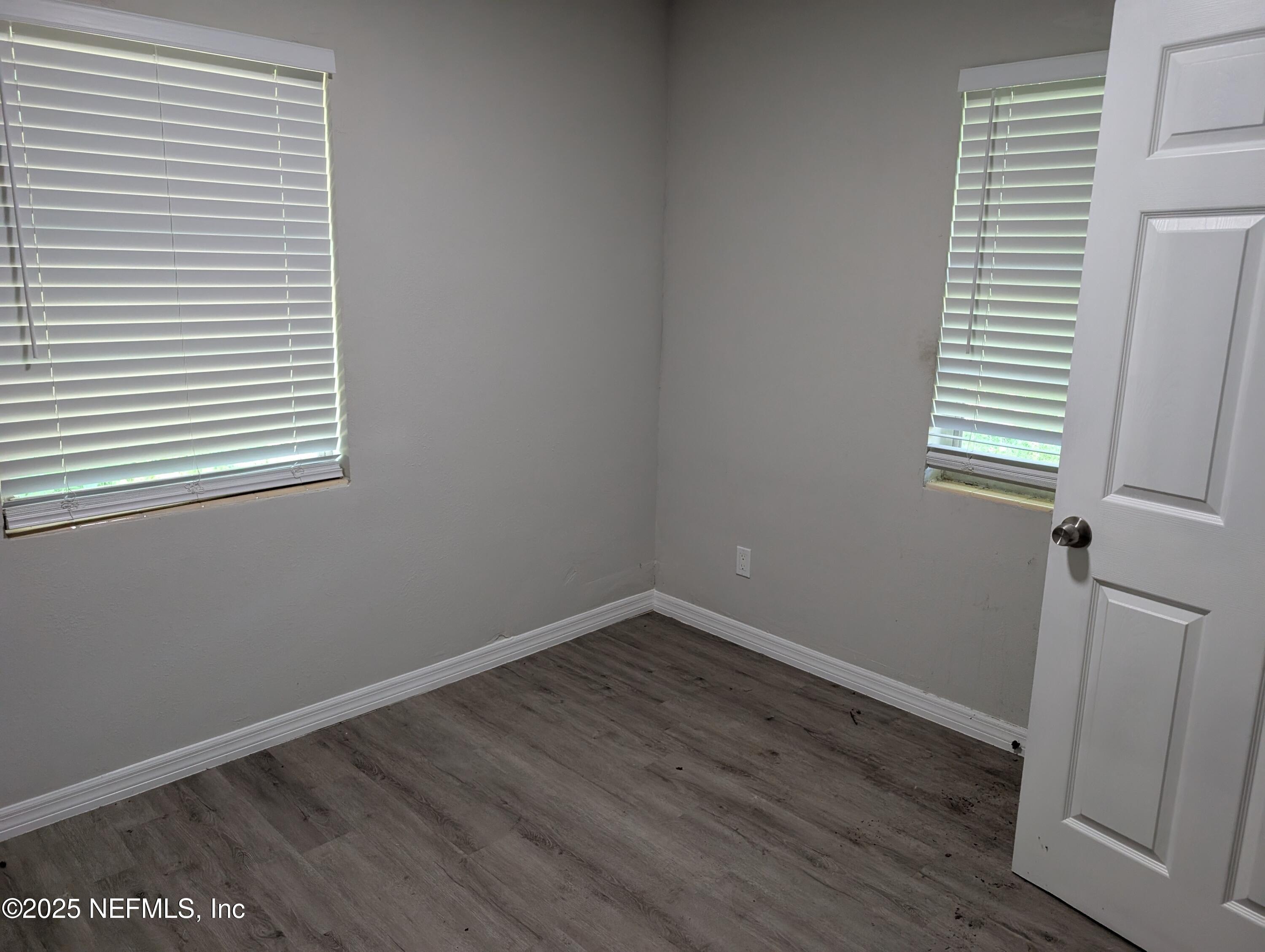1339 Ellis Road South Jacksonville, FL 32205 - Photo 17 of 26 an empty room with wooden floor and windows