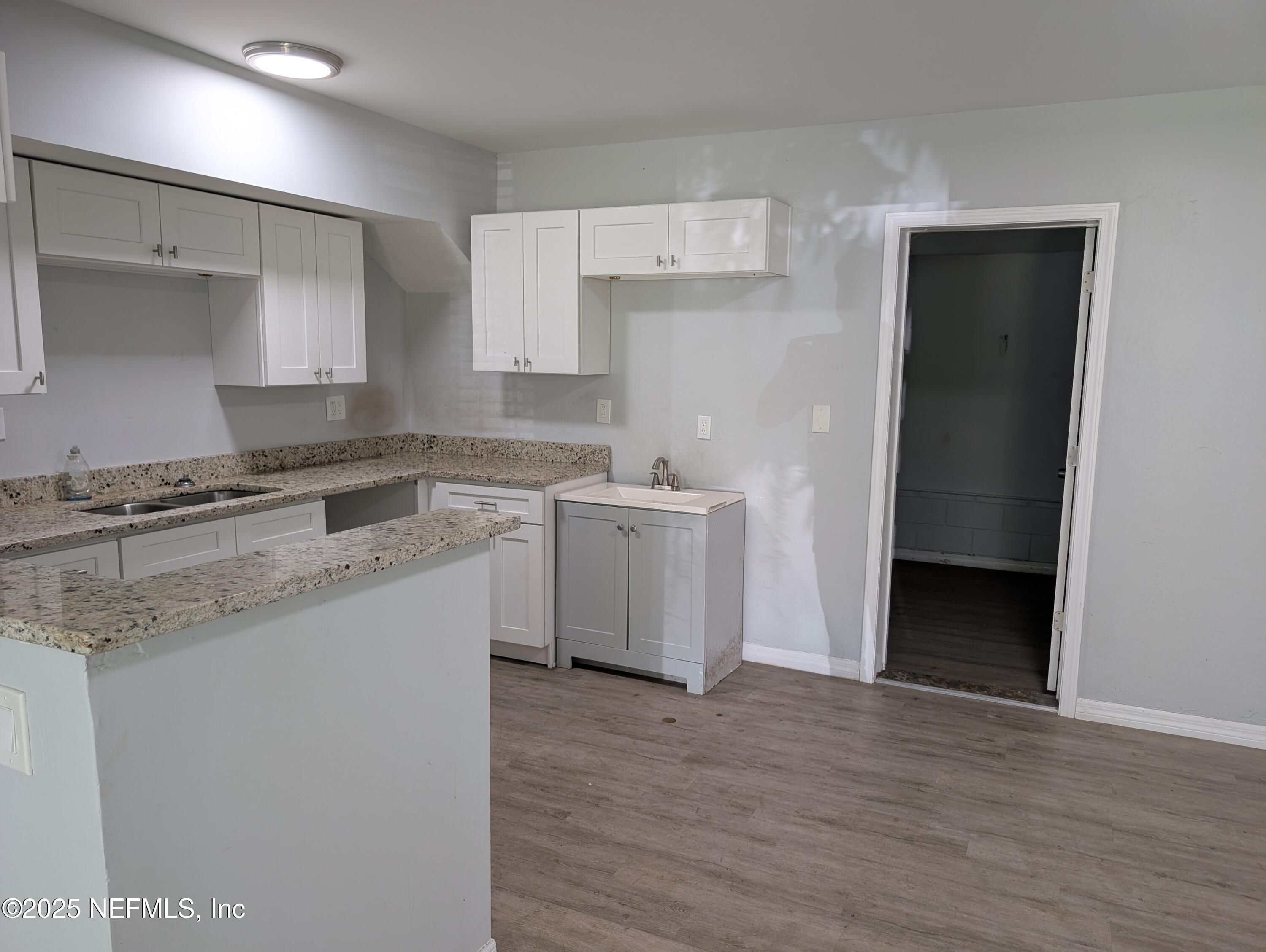 1339 Ellis Road South Jacksonville, FL 32205 - Photo 9 of 26 a kitchen with a sink cabinets and wooden floor