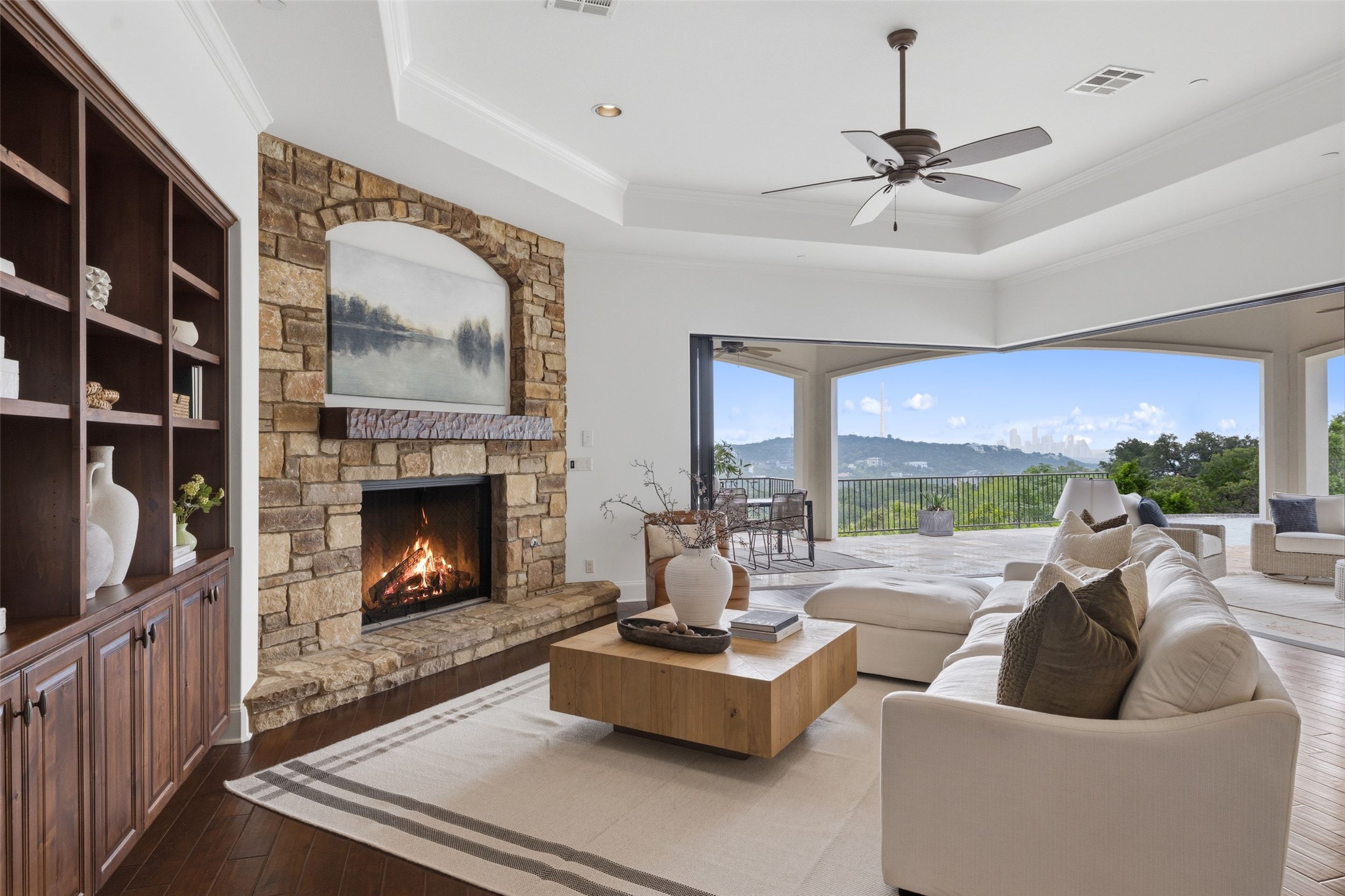 1414 The High Road Austin, TX 78746 - Photo 10 of 40 An inviting hearth and built-in shelving complement expansive views in this sun-filled living space.