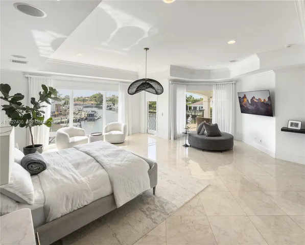 a bedroom with a bed large window and potted plant