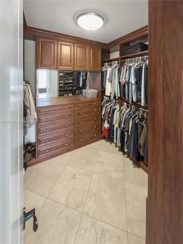 a view of walk in closet with clothes and shoes