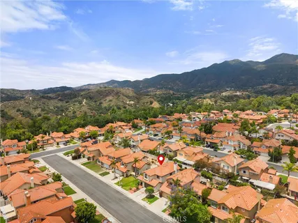 an aerial view of residential houses with outdoor space and trees