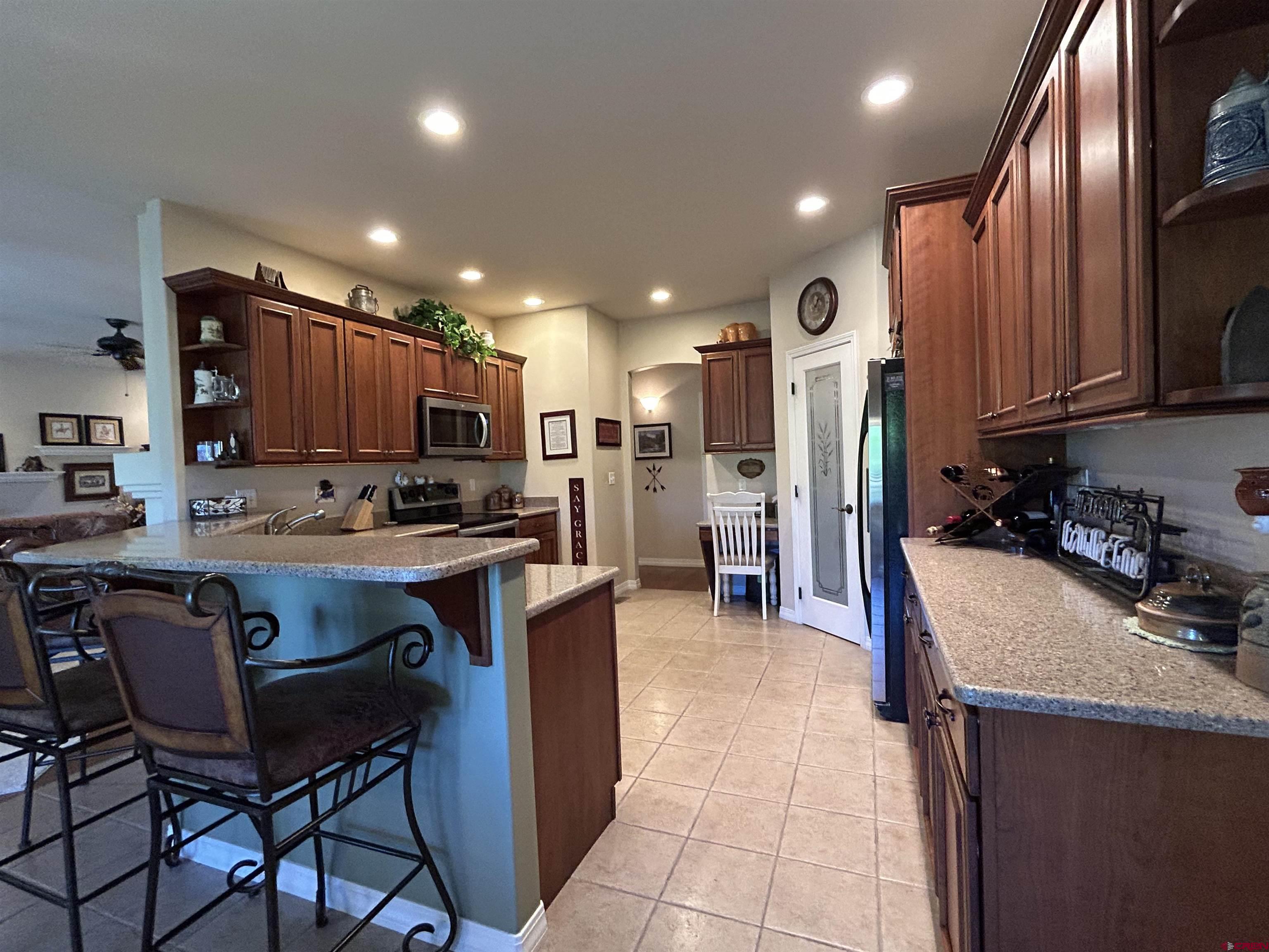 850 Southeast Pinyon Street Cedaredge, CO 81413 - Photo 12 of 45 a kitchen with stainless steel appliances granite countertop a sink refrigerator and cabinets