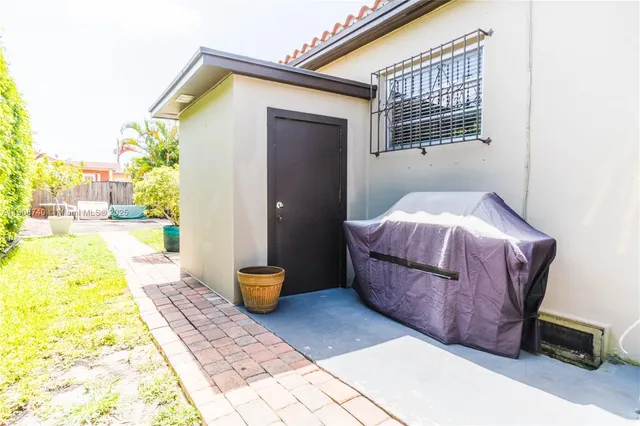 a view of a house with a yard and potted plants