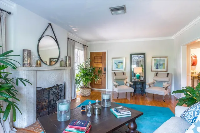 a living room with furniture fireplace and a large window