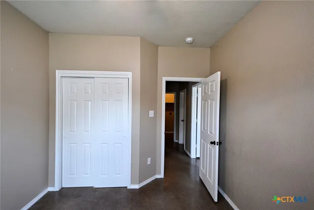 a view of a hallway with closet and wooden floor