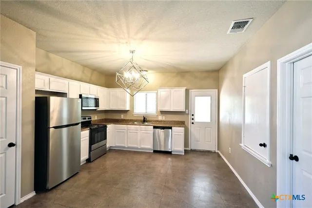 a kitchen with a refrigerator and a sink