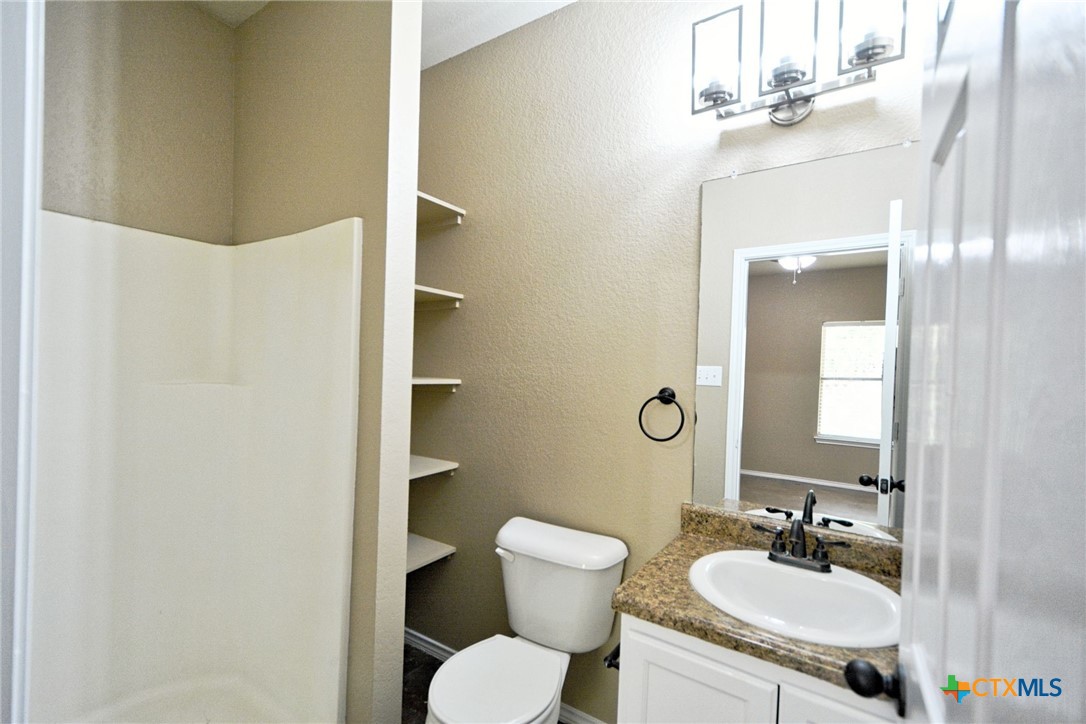107 Rosedale Avenue New Braunfels, TX 78130 - Photo 10 of 21 a bathroom with a granite countertop sink toilet and mirror