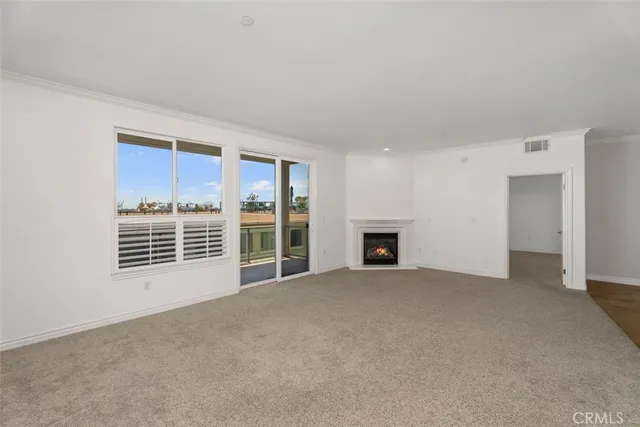 a view of an empty room with a fireplace and a window