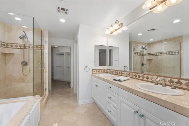 a bathroom with a granite countertop double vanity sink mirror shower and double