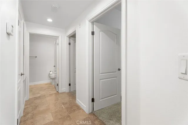 a view of a hallway with closet and a bathroom