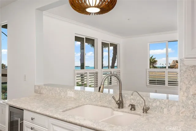 a kitchen with granite countertop a stove and a white cabinets
