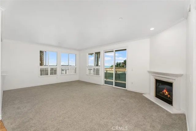 a view of an empty room with a fireplace and a window