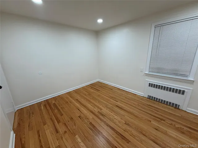 a view of a room with wooden floor and white walls