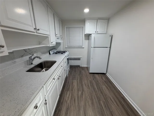a kitchen with a sink a refrigerator and cabinets
