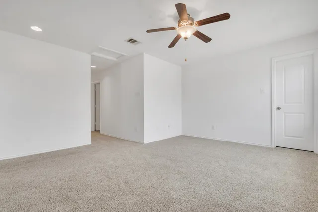 an empty room with closet and fan