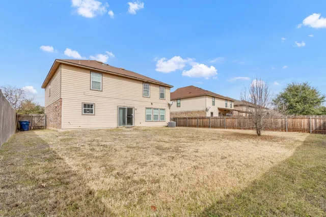 a big house with a yard and wooden fence