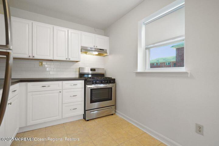 151 Spring Lake Garden Court, Unit 119 Spring Lake, NJ 07762 - Photo 2 of 8 a kitchen with stainless steel appliances granite countertop white cabinets and stove top oven