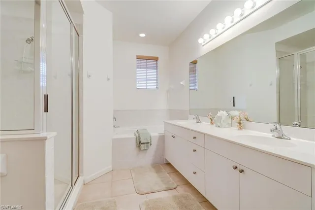 a spacious bathroom with a double vanity sink a mirror and a toilet
