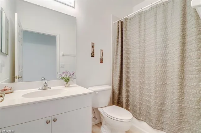 a bathroom with a sink a toilet and shower curtain