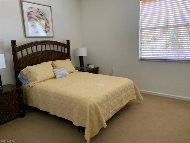 a large bed sitting in a bedroom next to a window