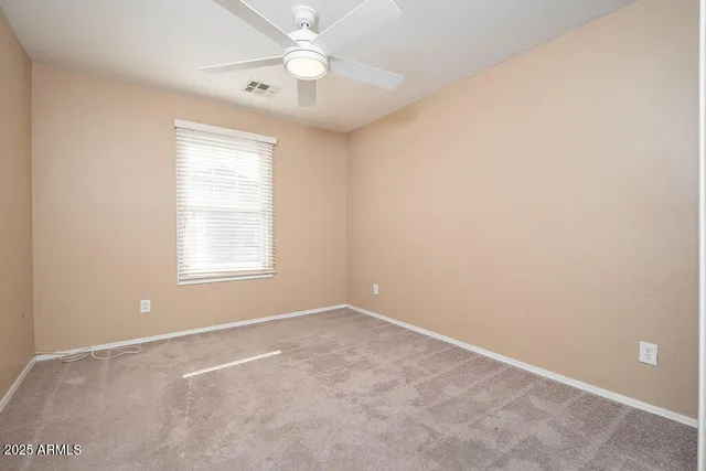 an empty room with a window and a fan