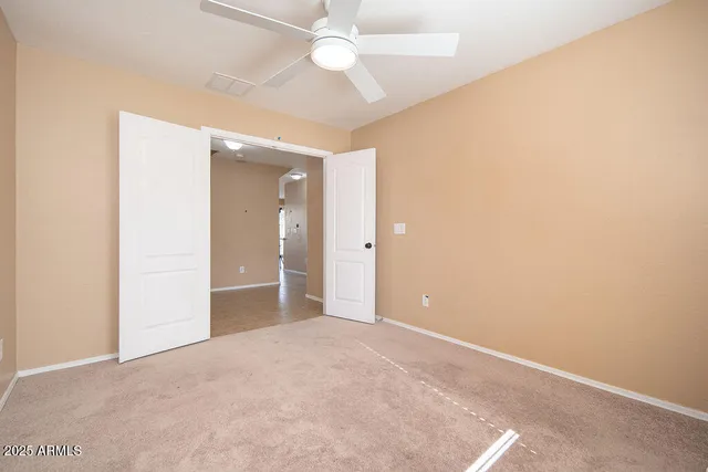 an empty room with fan and entryway
