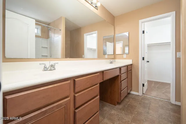a spacious bathroom with a double vanity sink a mirror and a shower