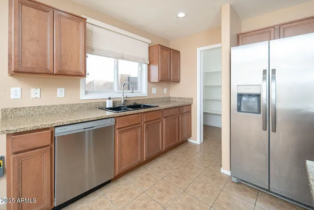 a kitchen with stainless steel appliances granite countertop a refrigerator and a sink