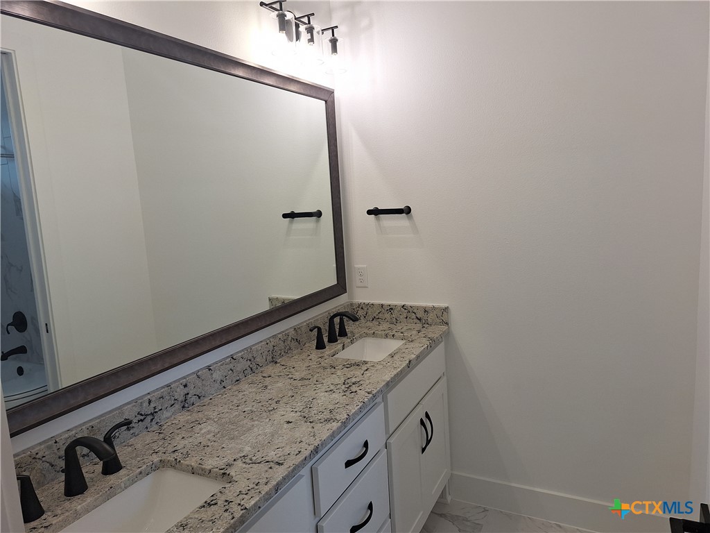 120 Strada Luca Florence, TX 76527 - Photo 15 of 17 a bathroom with a granite countertop sink and vanity