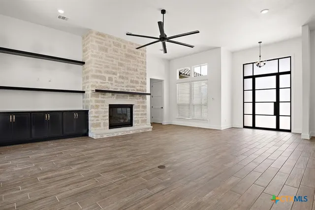 an empty room with windows and fireplace