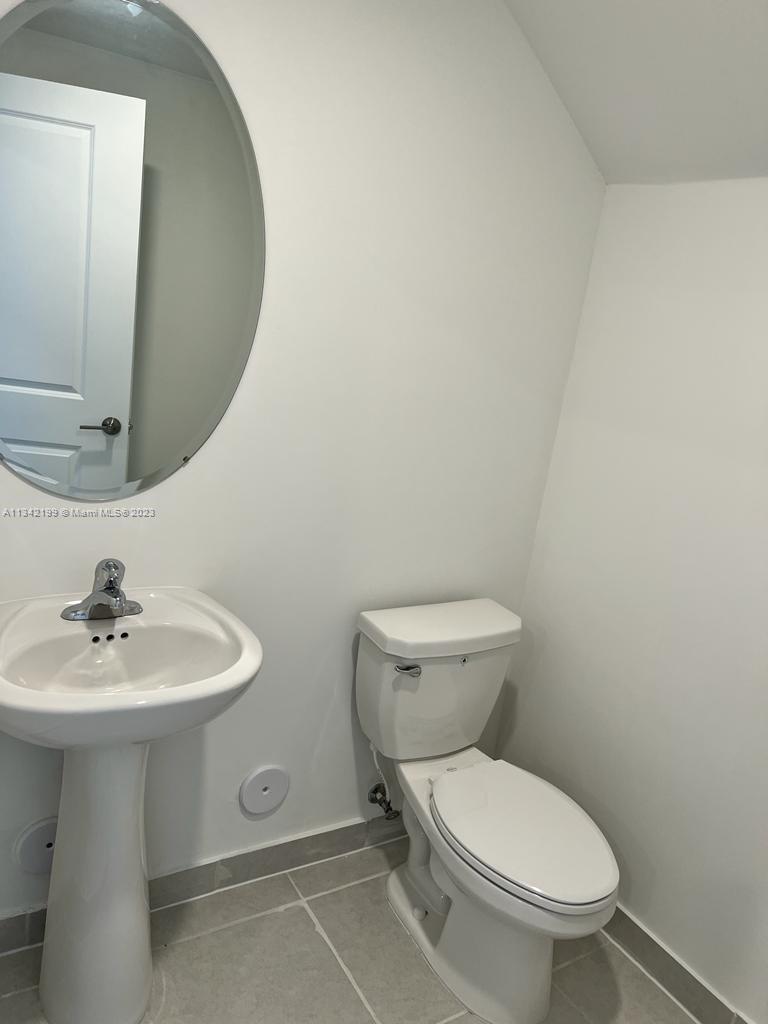 2633 Southeast 10th Street, Unit 2633 Homestead, FL 33035 - Photo 11 of 42 a bathroom with a toilet sink and mirror