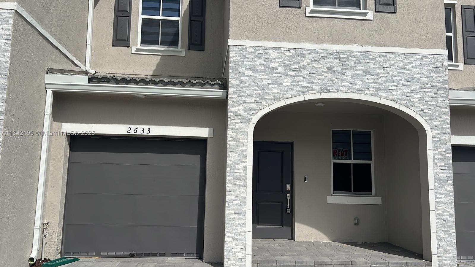 2633 Southeast 10th Street, Unit 2633 Homestead, FL 33035 - Photo 23 of 42 a front view of a house with garage