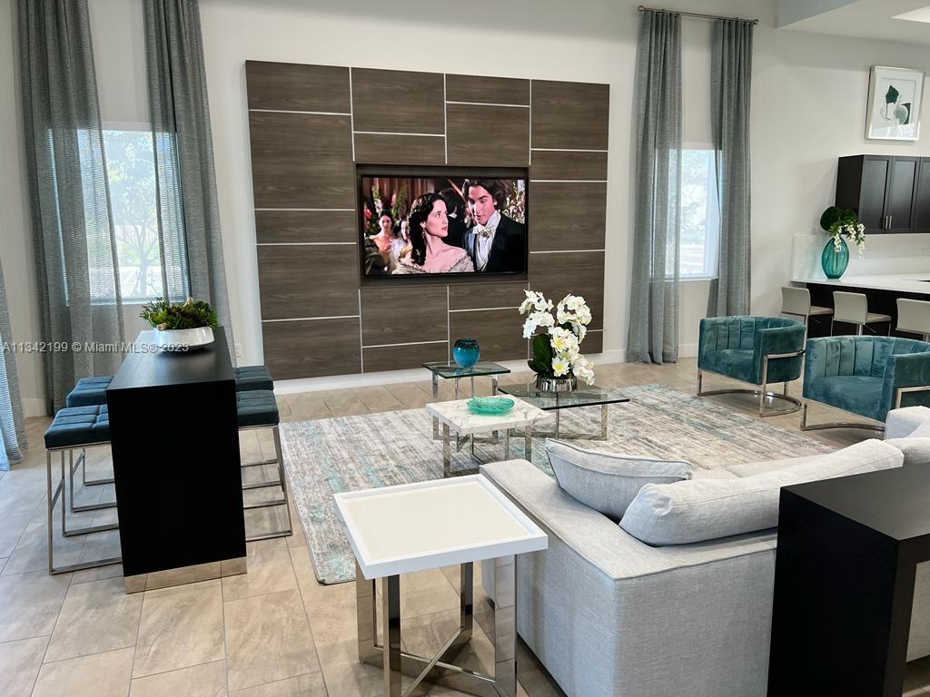 2633 Southeast 10th Street, Unit 2633 Homestead, FL 33035 - Photo 28 of 42 a living room with furniture a flat screen tv and a wall painting
