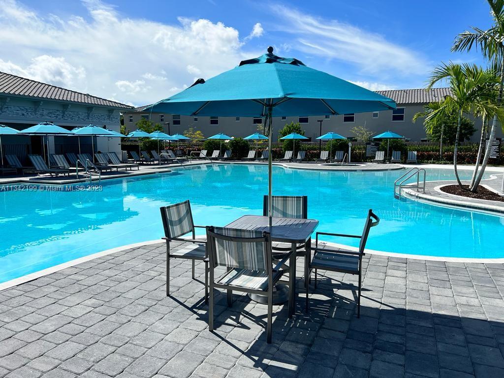 2633 Southeast 10th Street, Unit 2633 Homestead, FL 33035 - Photo 39 of 42 a view of a patio with table and chairs under an umbrella