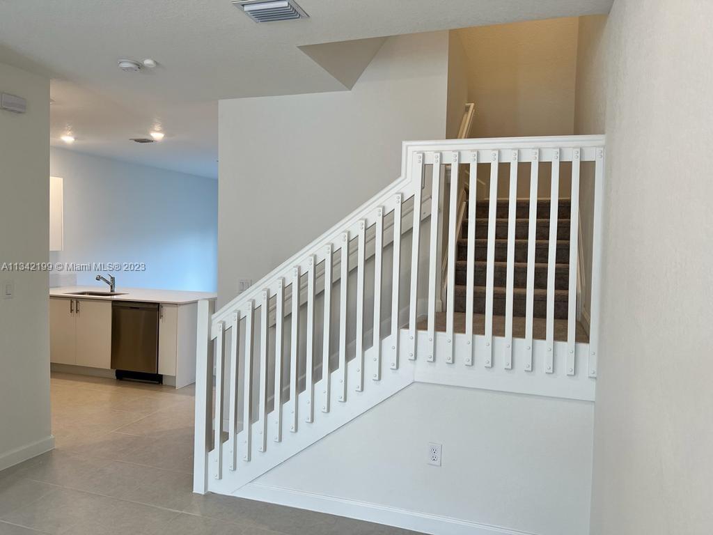 2633 Southeast 10th Street, Unit 2633 Homestead, FL 33035 - Photo 4 of 42 a view of staircase with white walls