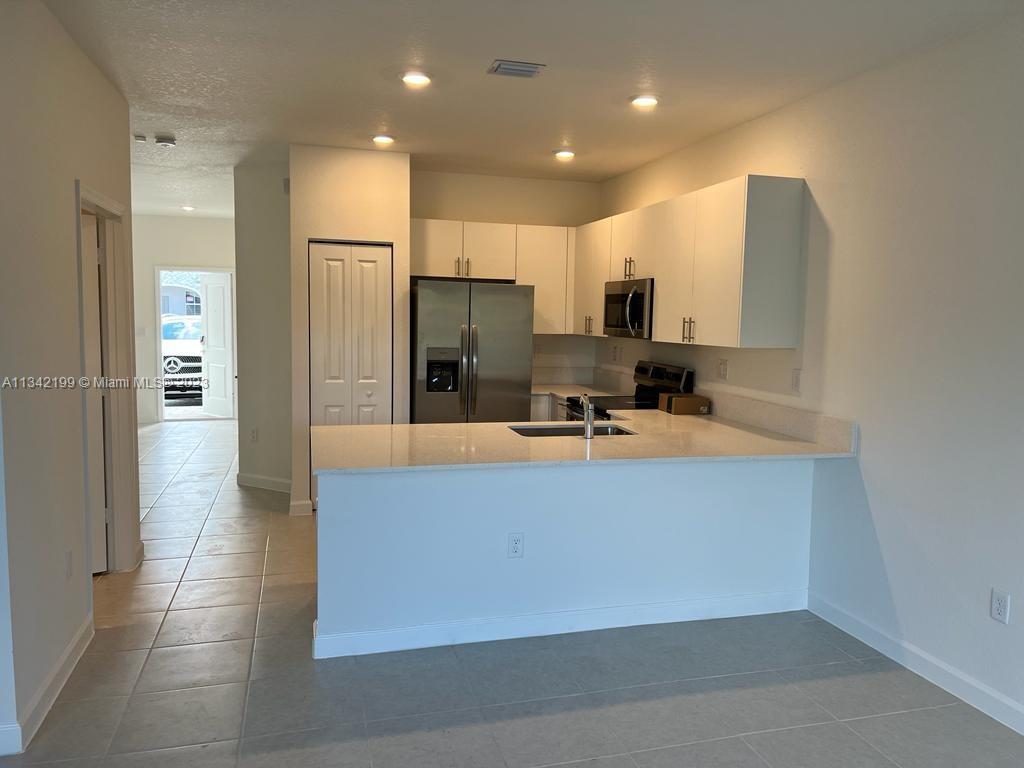 2633 Southeast 10th Street, Unit 2633 Homestead, FL 33035 - Photo 9 of 42 a view of kitchen with stainless steel appliances a refrigerator and a sink