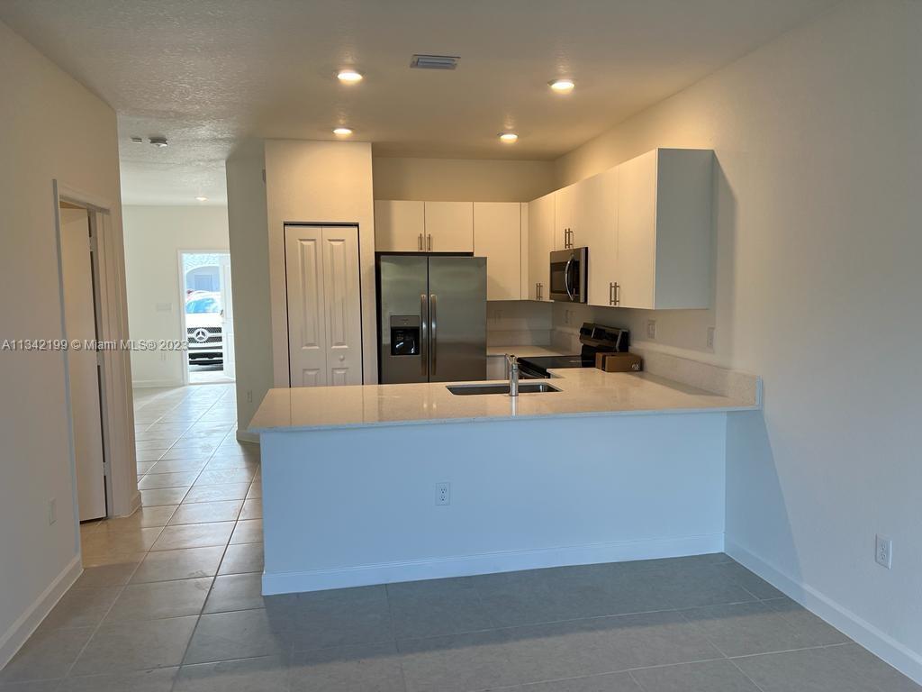 2633 Southeast 10th Street, Unit 2633 Homestead, FL 33035 - Photo 10 of 42 a large kitchen with stainless steel appliances a refrigerator and a sink