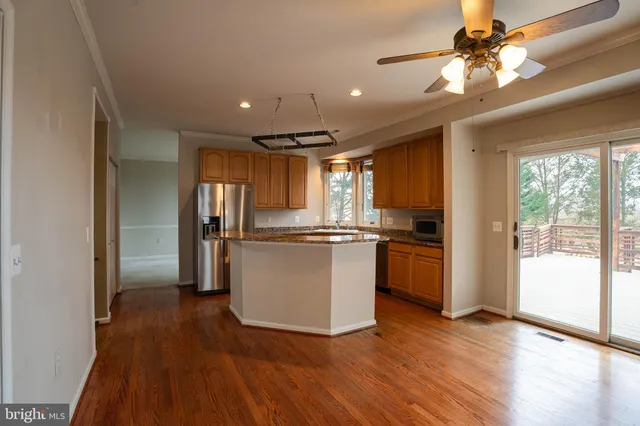 a view of kitchen with refrigerator and wooden floor