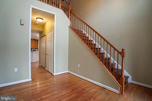 a view of a hallway with wooden floor and staircase