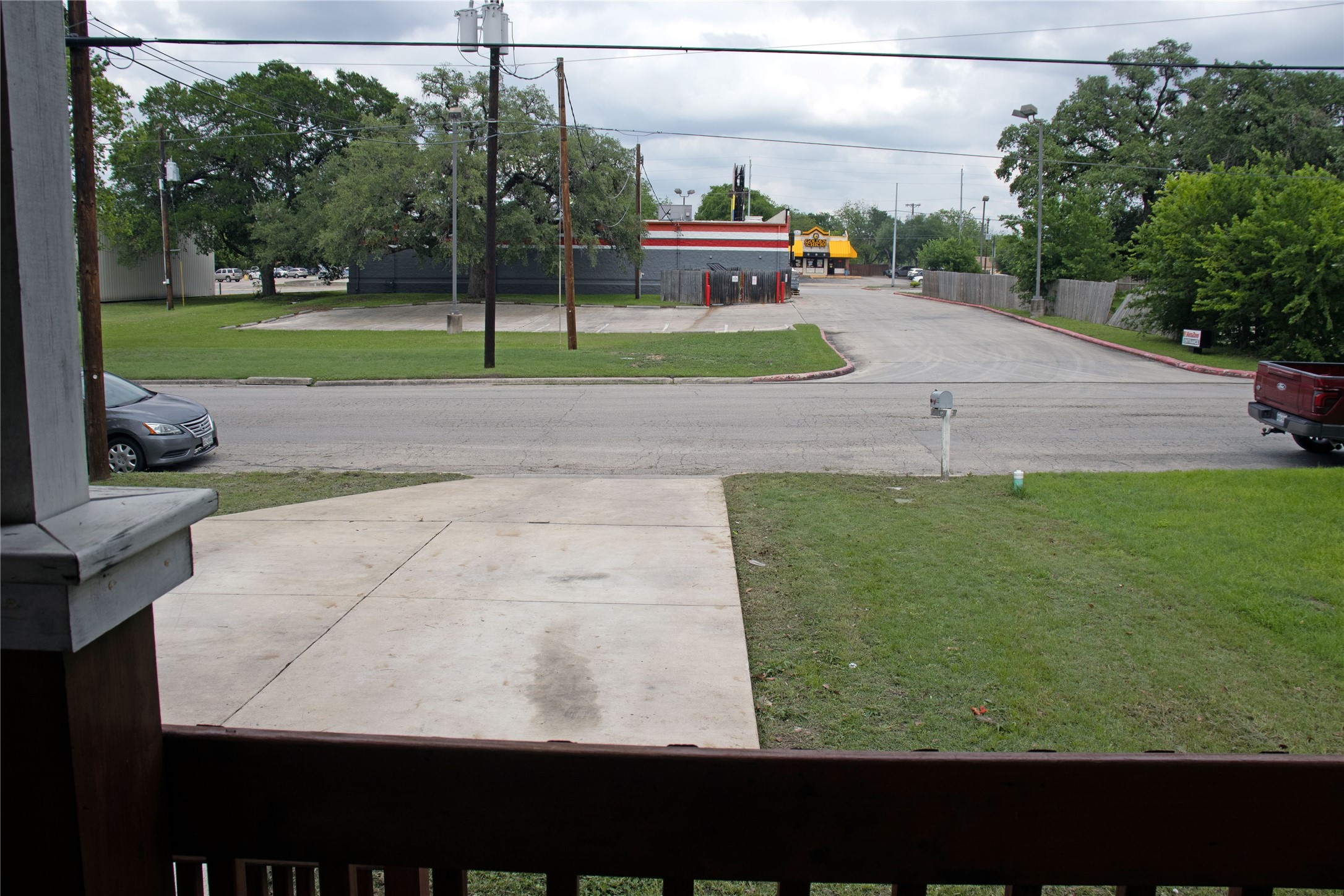 633 South Commerce Street Lockhart, TX 78644 - Photo 7 of 29 Concrete driveway with a manicured lawn area
