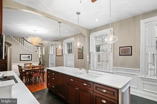 a large kitchen with a sink a counter space and stainless steel appliances