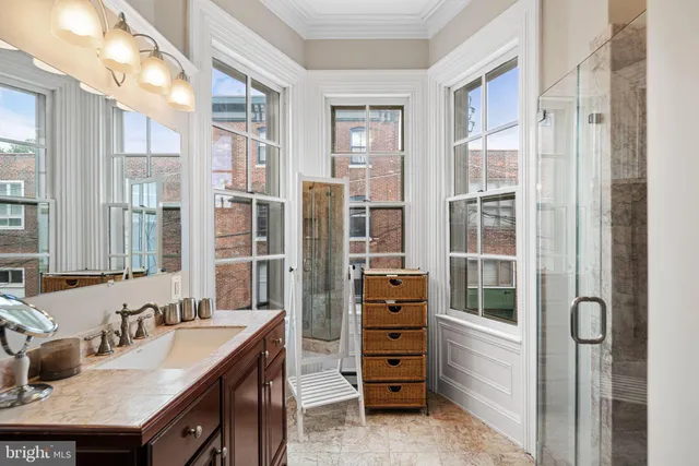 a en suite bathroom with a granite countertop sink and a mirror