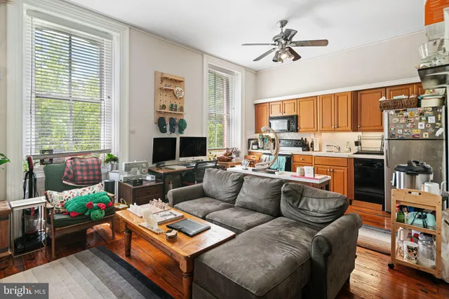 a kitchen with stainless steel appliances granite countertop a stove a sink dishwasher and a dining table with wooden floor